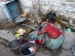 Ce bidonville de la zone pilote est déjà équipé d'eau 24h/24. Cette femme fait sa lessive à un robinet privé dans la cour de sa maisonnette